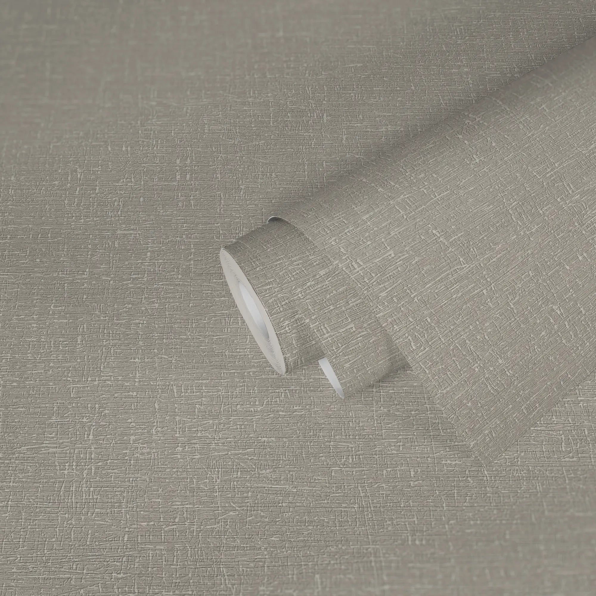 Billede af en rullet tapetrulle i Alma Textured - Sand, der viser den elegante tekstur og farvetone.