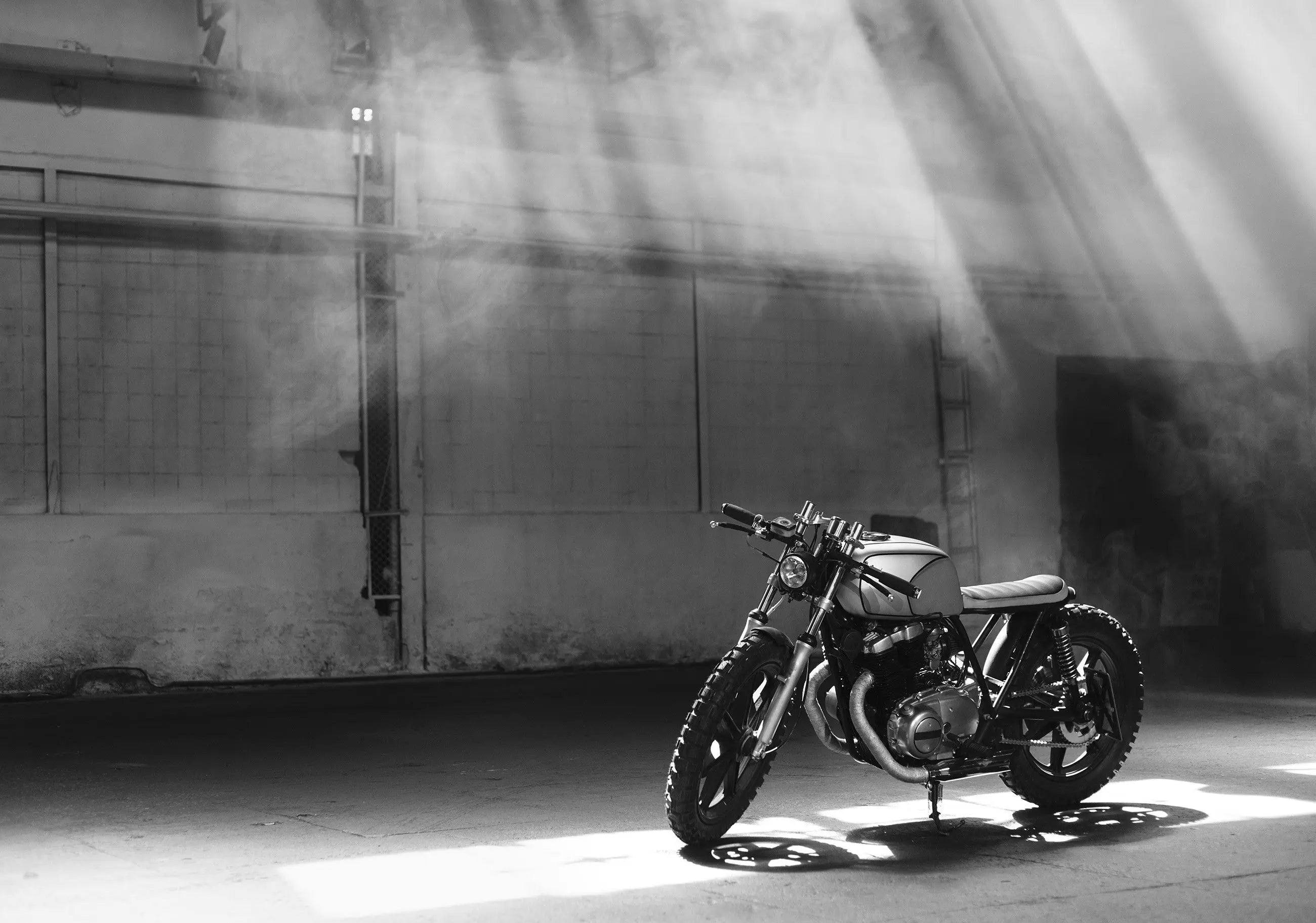 Billede 7 af Fototapet - Café racer motorcykel i solstråler i industriel hal