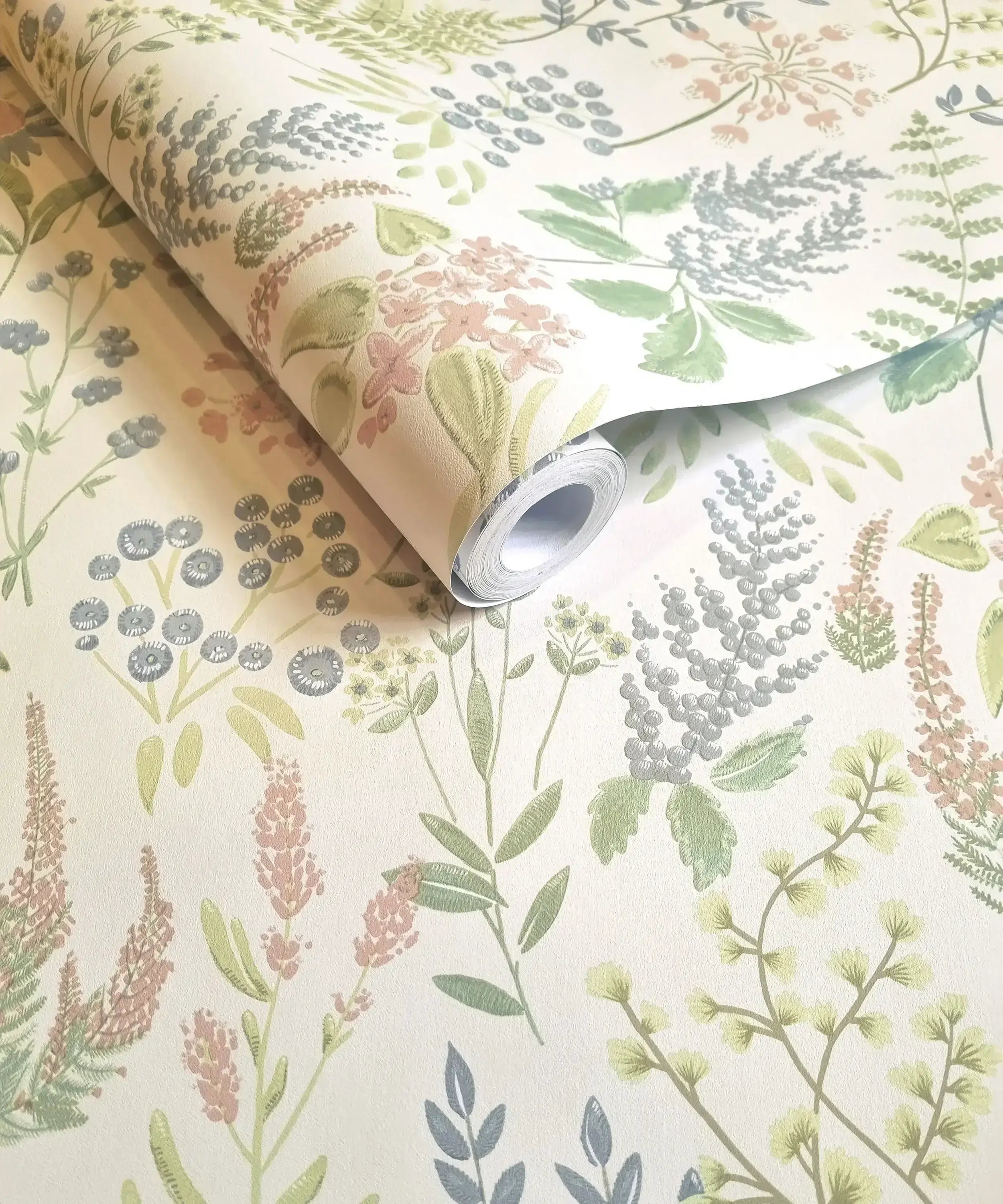 Nærbillede af en rulle Calvert Meadows - Pink Cream tapet, der viser sit blomstermønster i pastelfarver.