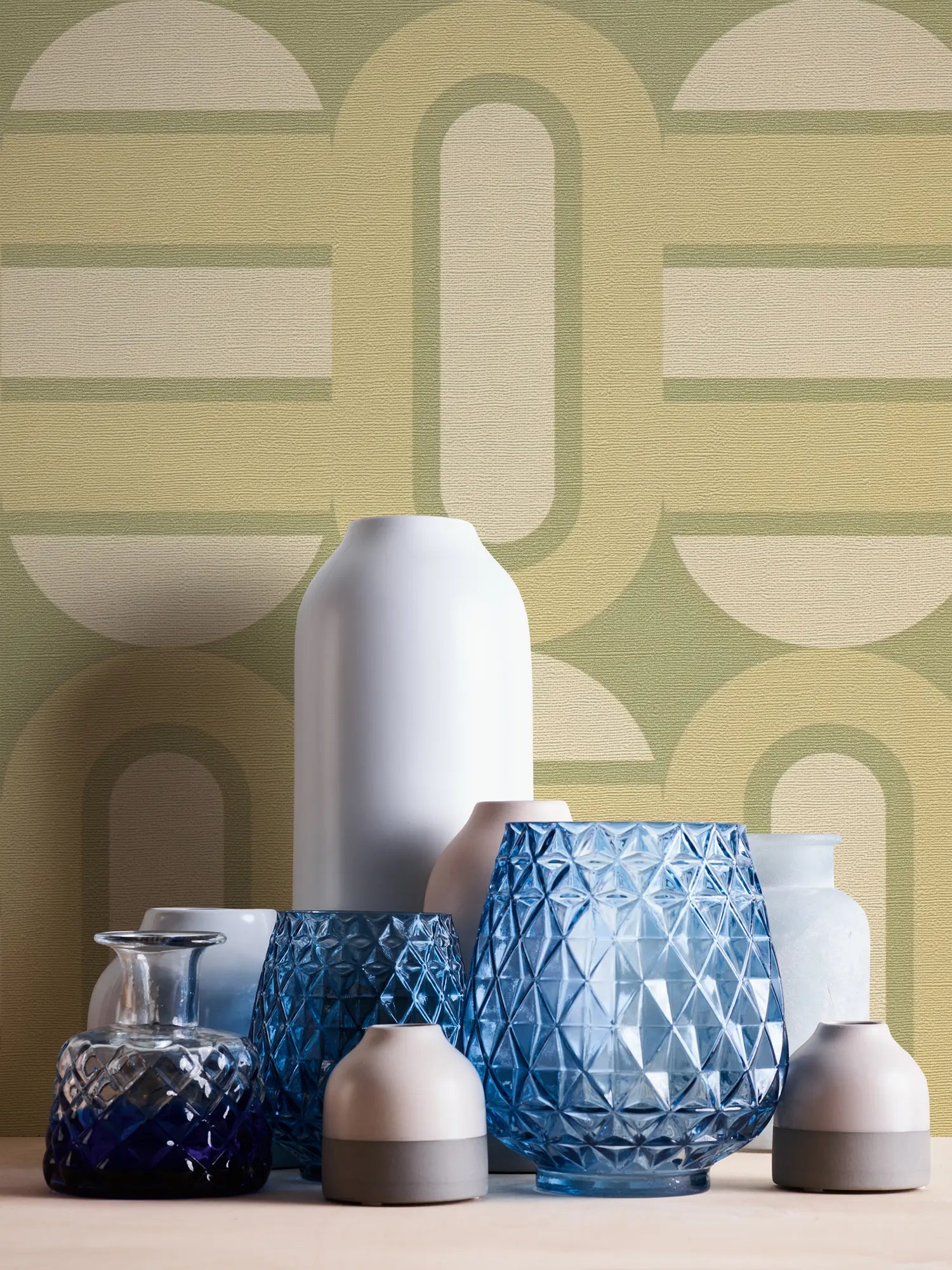 Tæt på Gloria - Vintage Olive tapet med en samling af dekorative vaser foran.