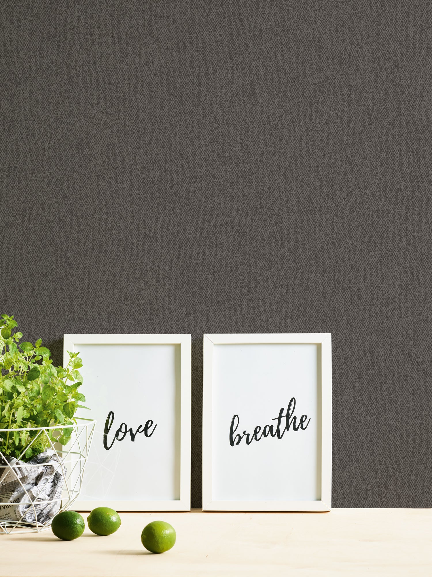 Interiør med Imperial Linen - Slate tapet, der viser to indrammede billeder og en skål med limefrugter.