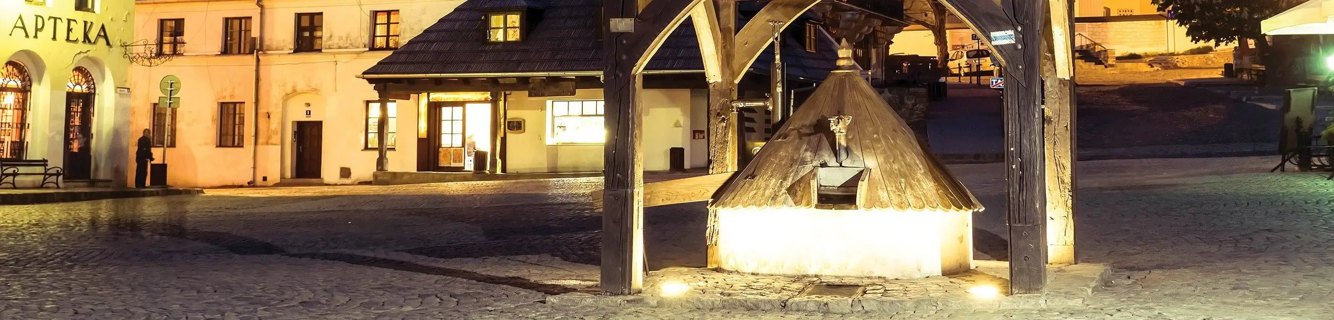 Billede 10 af Fototapet - Oplyst brønd på brostensbelagt torv med historiske bygninger