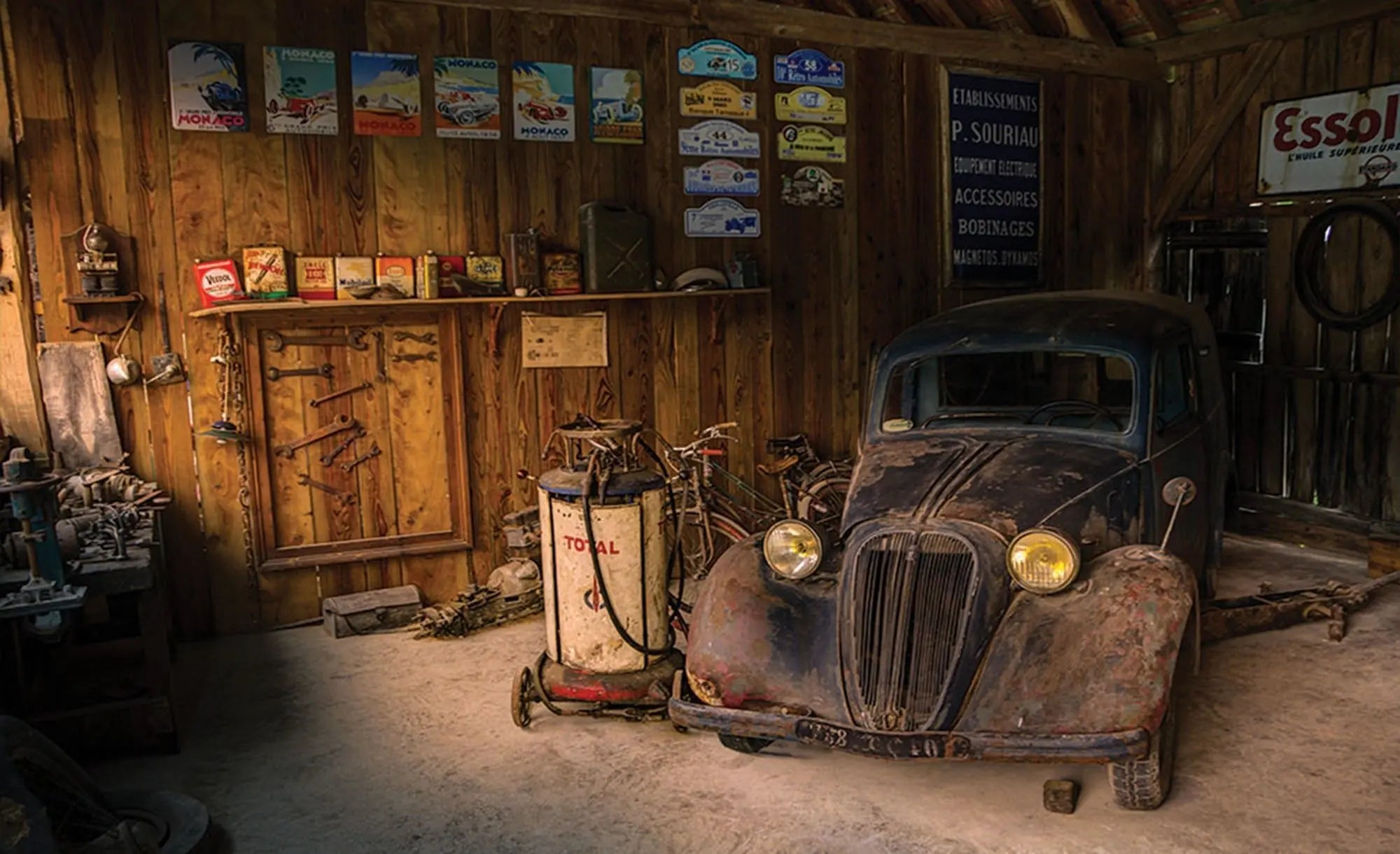 Billede 1 af Fototapet - Rustik garage med gammel sort bil og retro reklameskilte