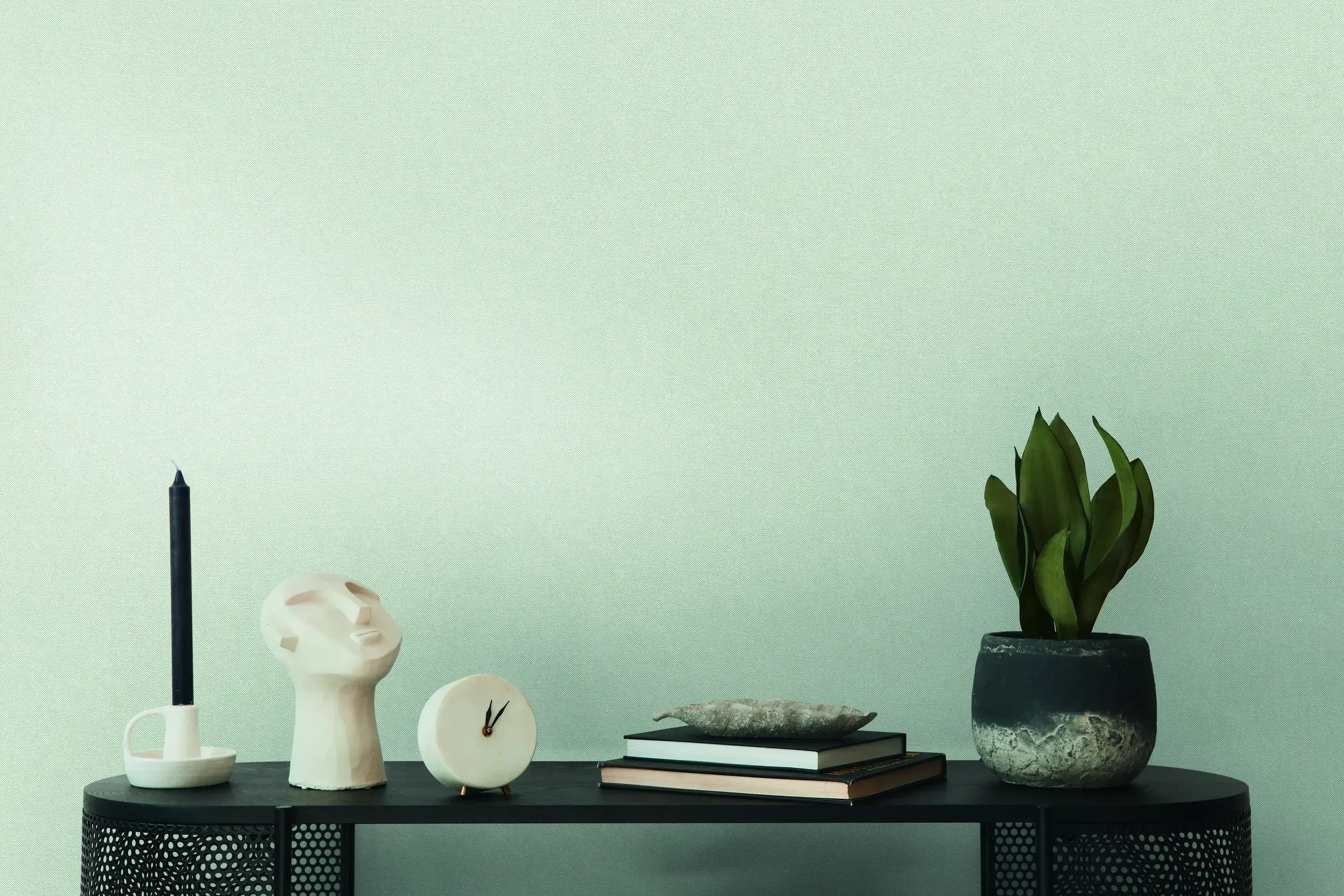 Interiørbillede med tapetet Serene Elegance - Slate i baggrunden, dekoreret med stilfulde objekter og en grøn plante på et bord.