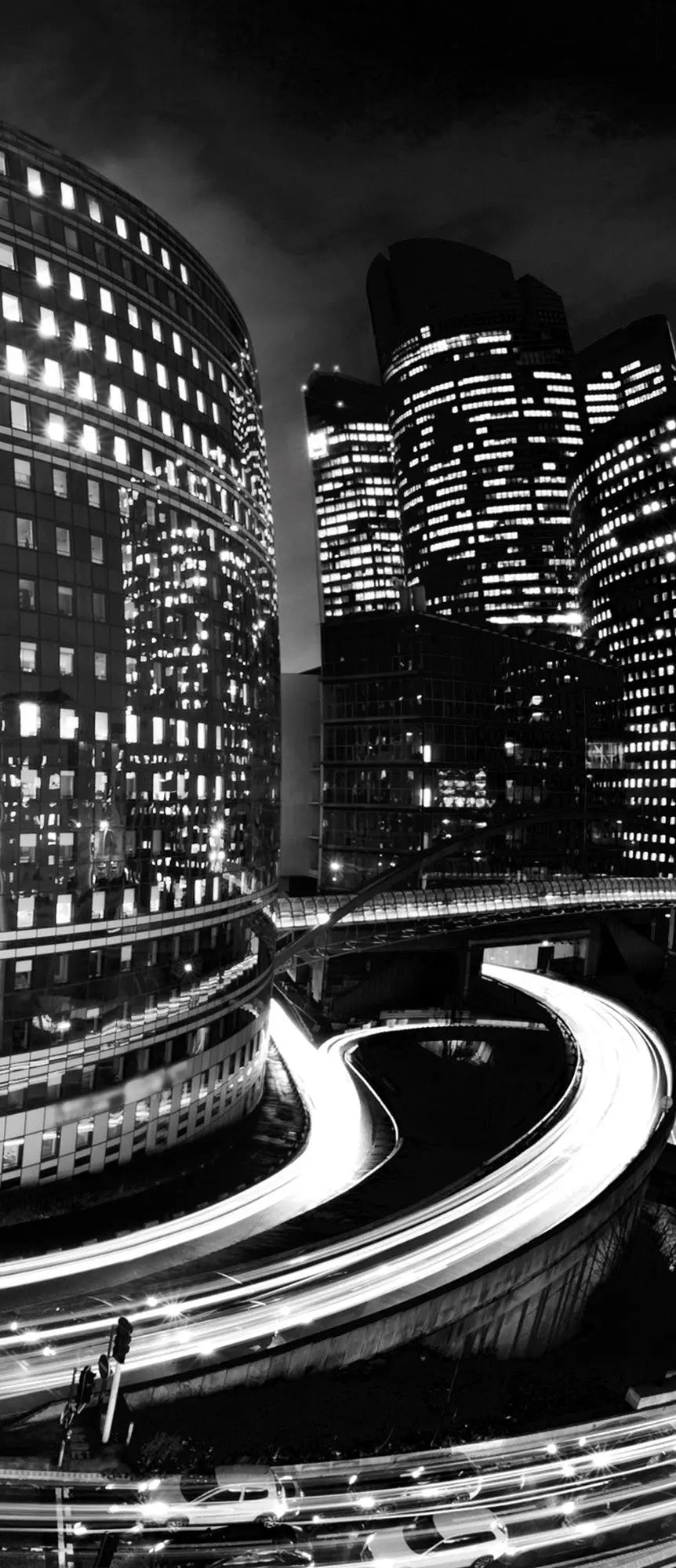 Billede 10 af Fototapet - Sort-hvidt bylandskab med lysende bygninger og motorvej