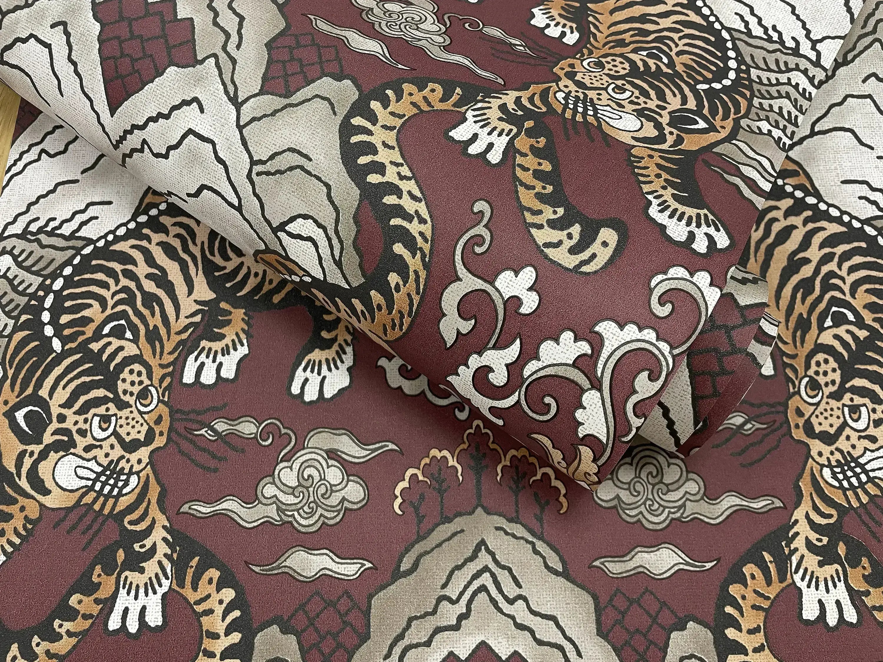 Tora - Maroon tapet zoomet ind på tekstur og design, der viser tigre og dekorative elementer.
