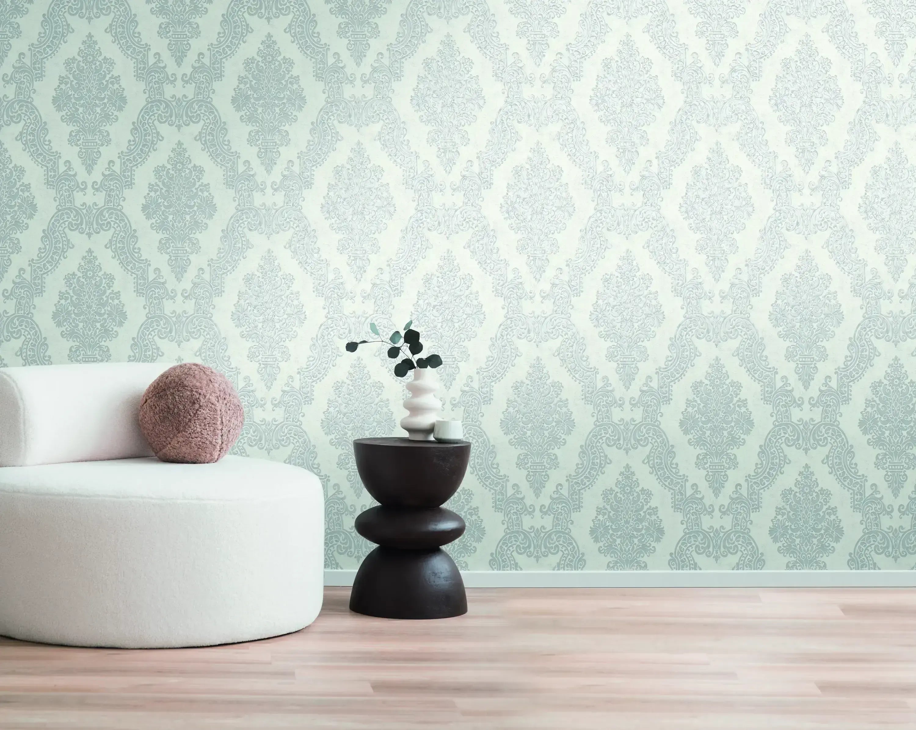Indretning af et rum med Baroque Elegance - Pearl tapet, der viser et elegant barokmønster i lysegrå farver, kombineret med moderne møbler.