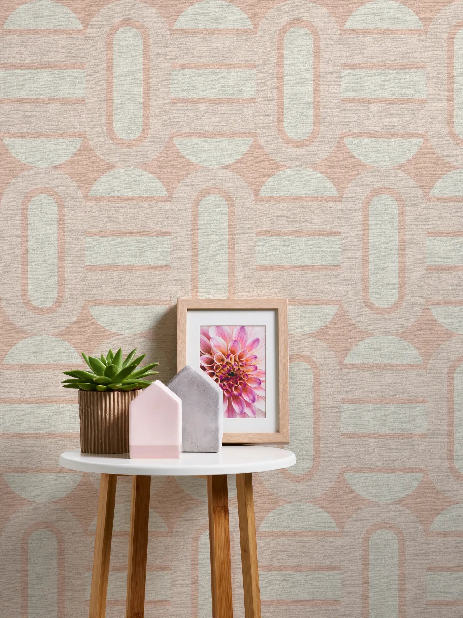 Dekorativ opsætning med sukulenter og et kunstnerisk billede foran Gloria - Blush Whisper tapet.