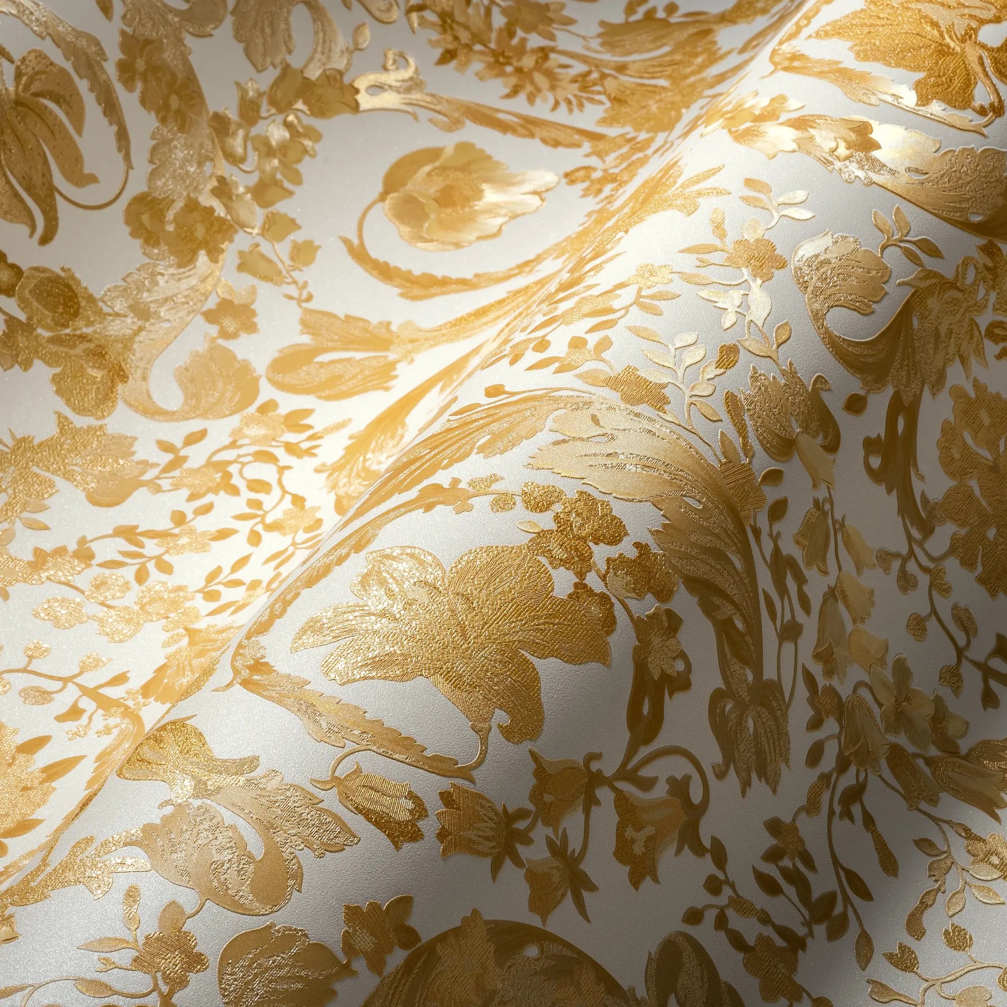 Nærbillede af Versace Virtus Heritage - Guld tapet, der fremviser den elegante, gyldne struktur og mønsterdetaljer.