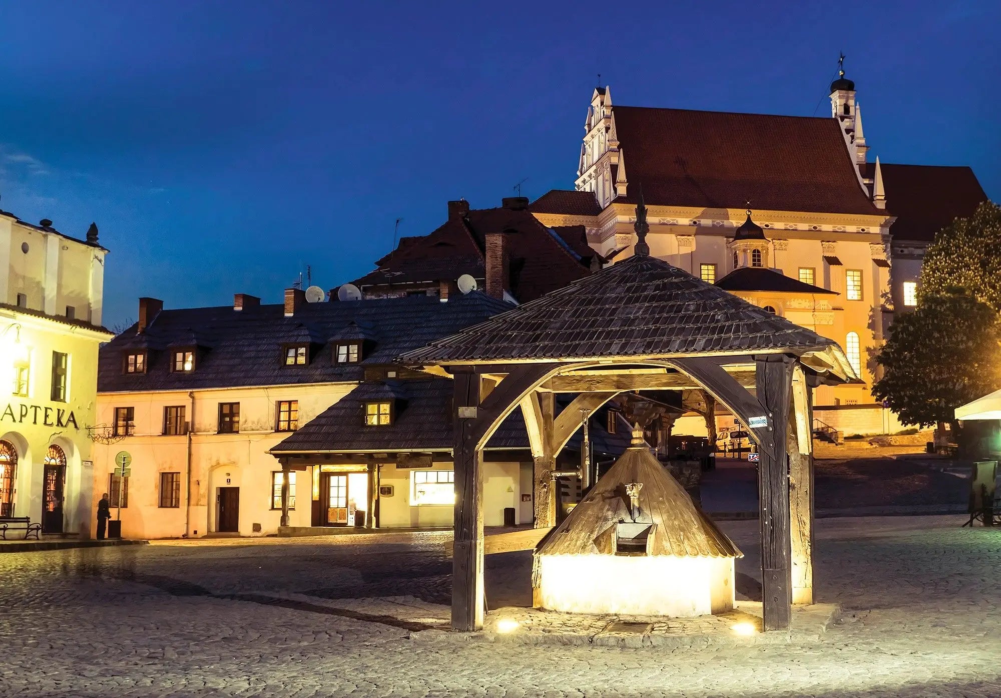 Billede 1 af Fototapet - Oplyst brønd på brostensbelagt torv med historiske bygninger
