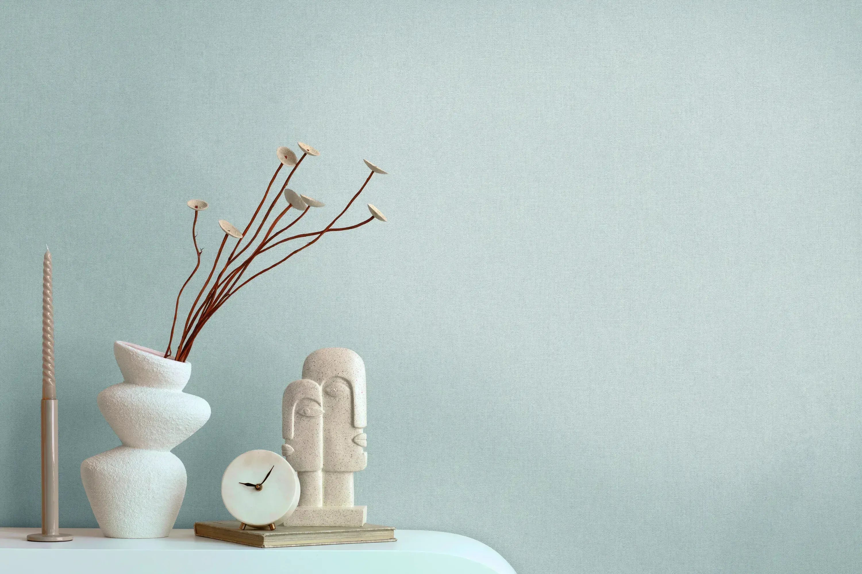 Serene Elegance - Aqua tapet i en moderne stue med dekorative genstande som vaser, en skulptur og et ur på en hylde, der skaber en rolig, stilfuld atmosfære.