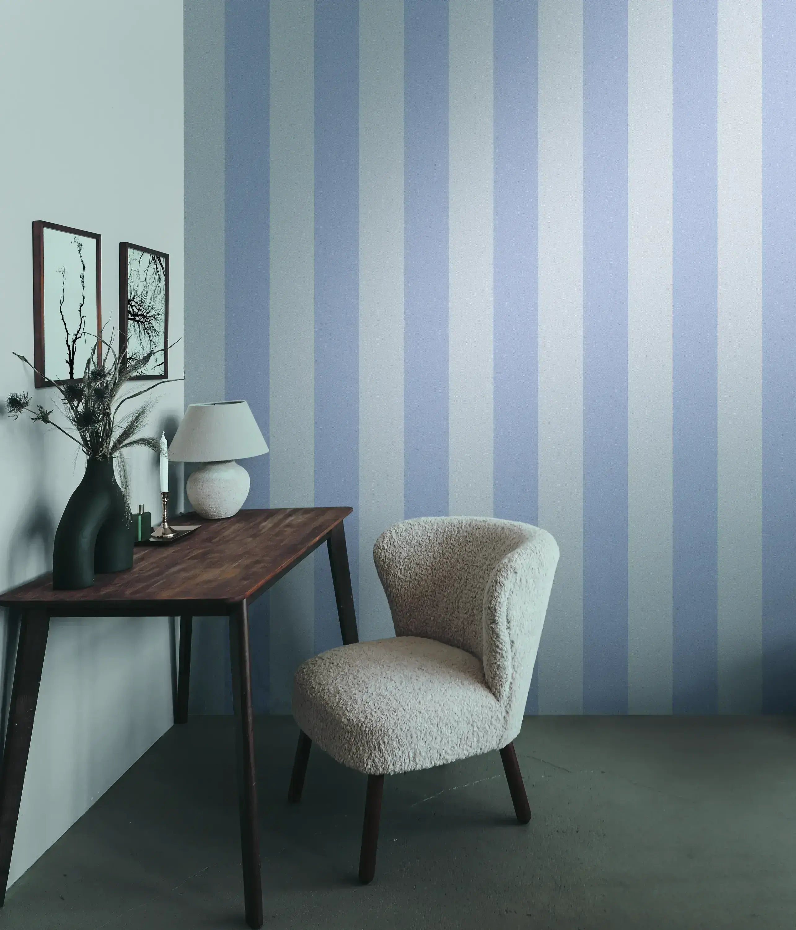 Striped Elegance - Sky tapet anvendt i rumindretning med stol og bord mod væggen, der viser det stribede design.