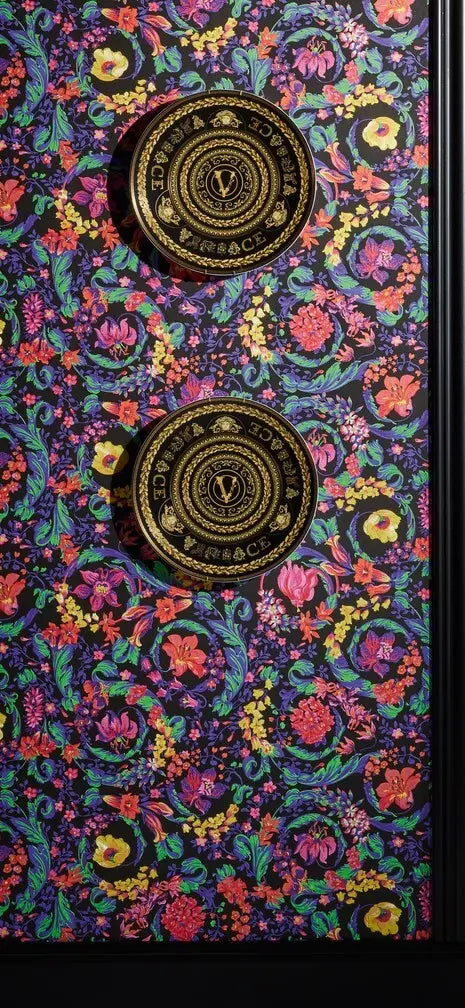 Versace Virtus Heritage tapet med guldmedaljer på et farverigt blomstret mønster, der fremhæver det luksuriøse design.